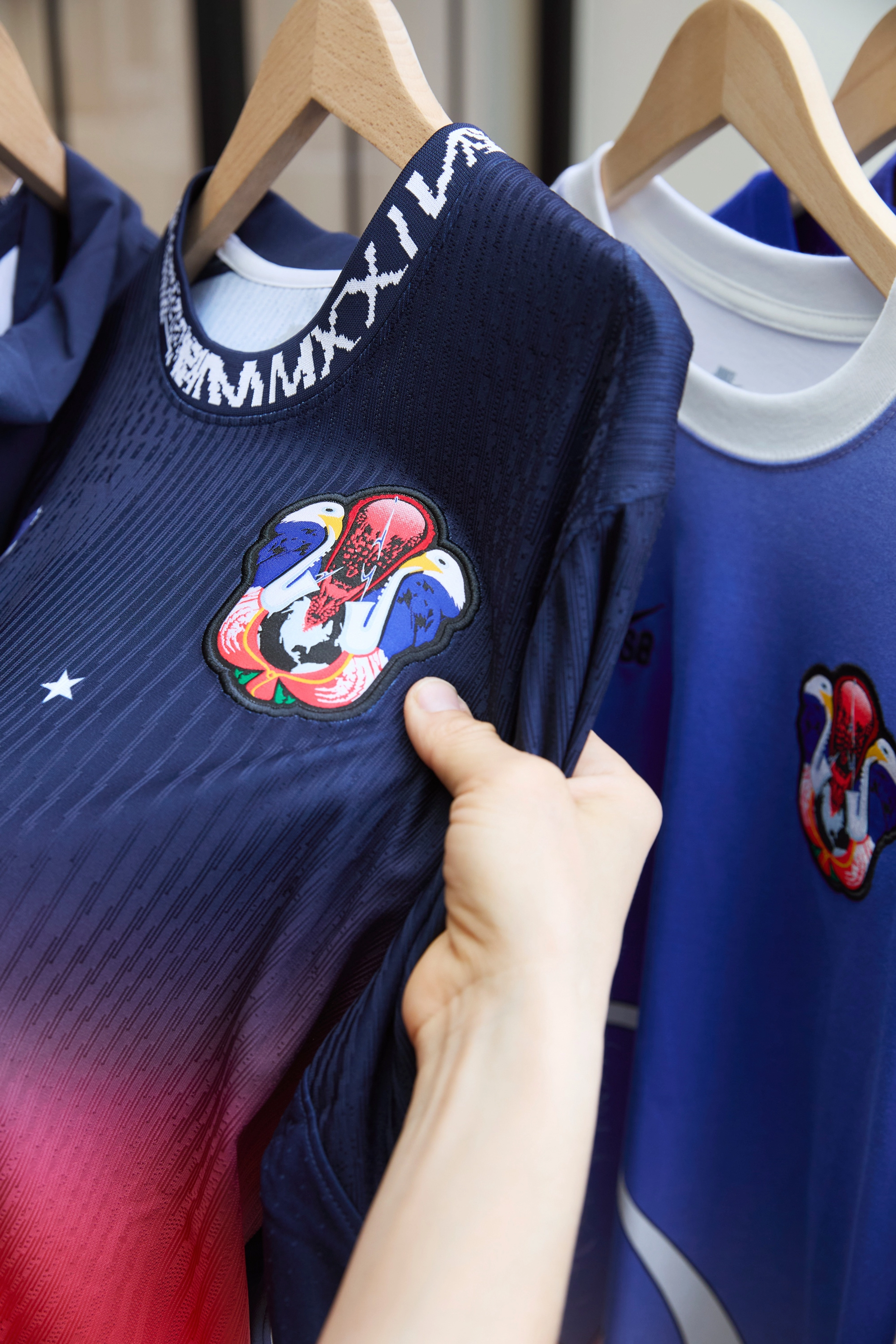 Close up view of Alexis Sablone's hand holding the shirt of USA skateboarding federation kit featuring the crest.