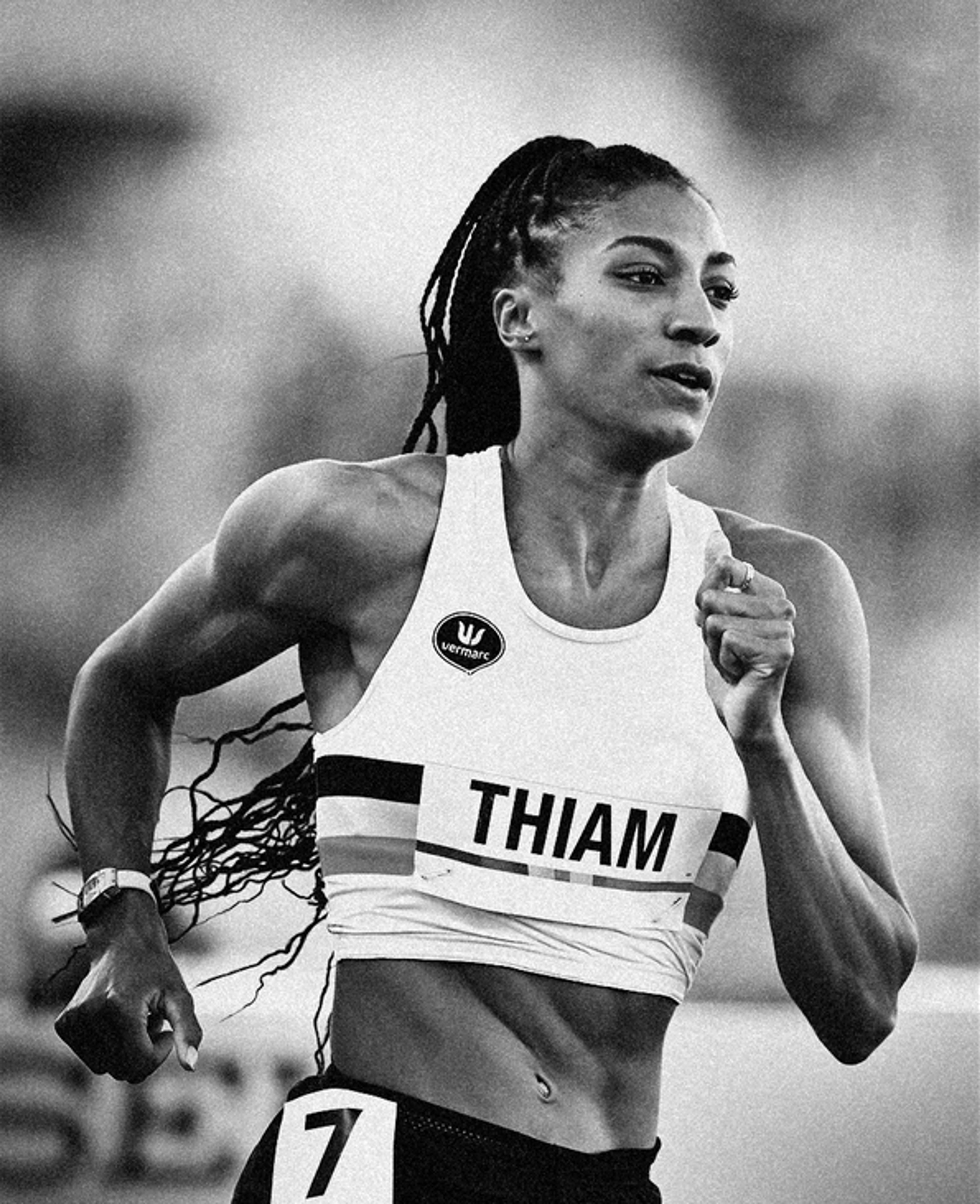 Black and white photo of Nafissatou Thiam running. Her long braids are pulled back into a ponytail as she pumps her arms during the race.