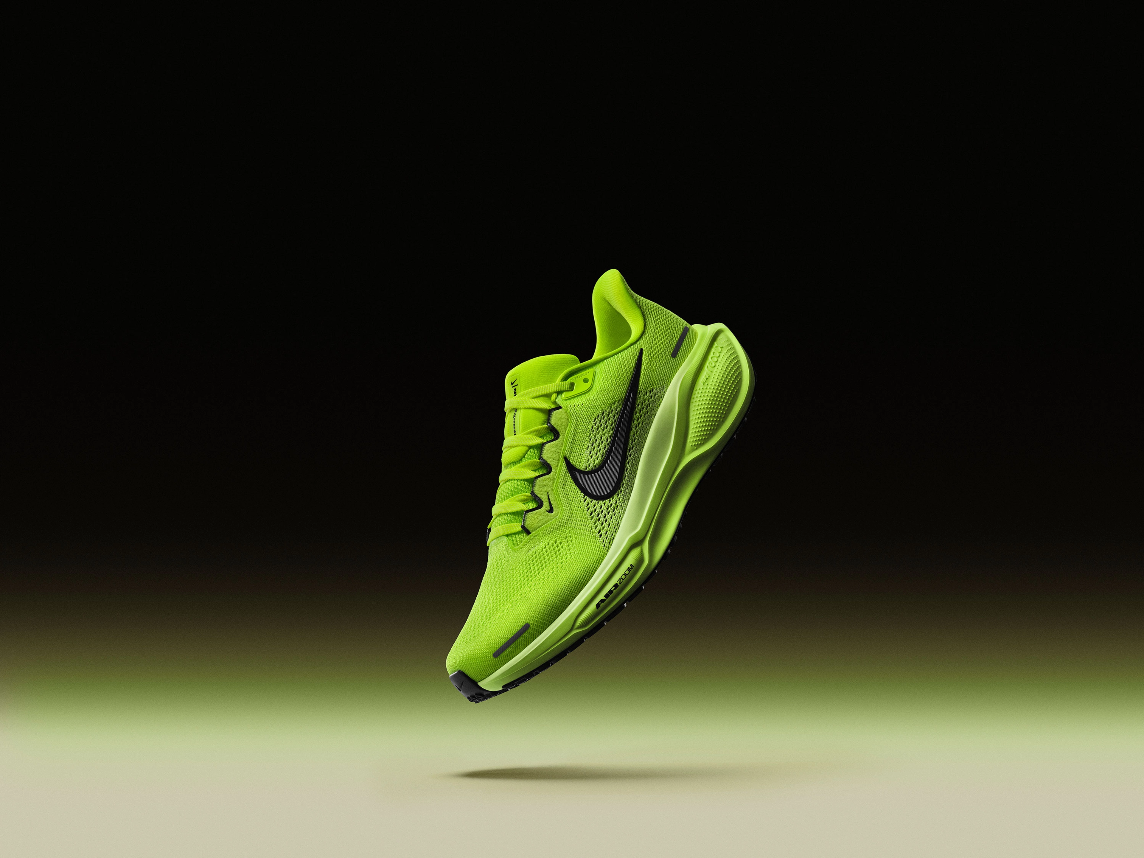 Front angled view of the Nike Pegasus 41 in the Volt green colorway. We see full-length ReactX foam and an Air Zoom Unit in the forefoot. Volt upper, Barely Volt midsole, black sole, with a black Nike Swoosh. The shoe floats above a cream floor, with volt green glow against a dark background.