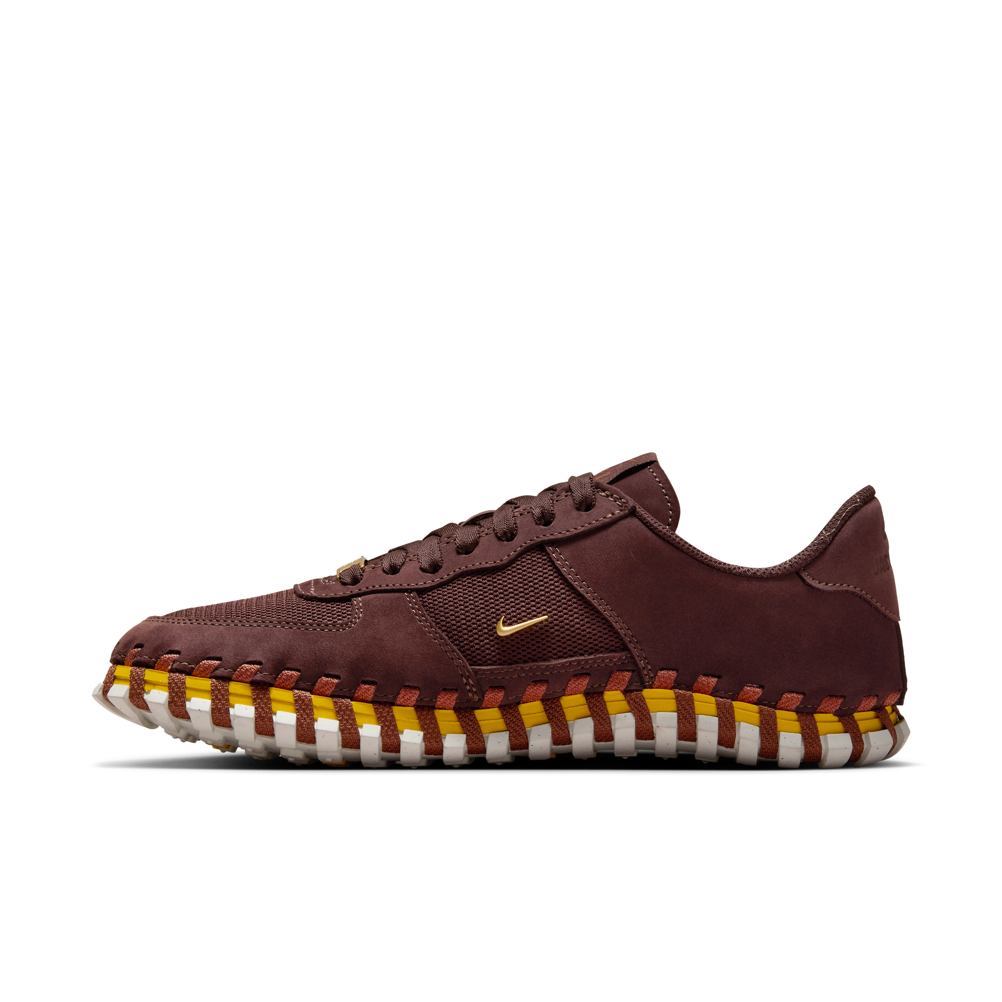 Left view of a Nike x Jacquemus J Force 1 Low LX SP with Earth brown upper, tour yellow midsole, and white sole. Includes, brown laces and AF1 lace tag in gold metal. There is a small metallic gold Swoosh on the shoe's side. The shoe floats on a black background.