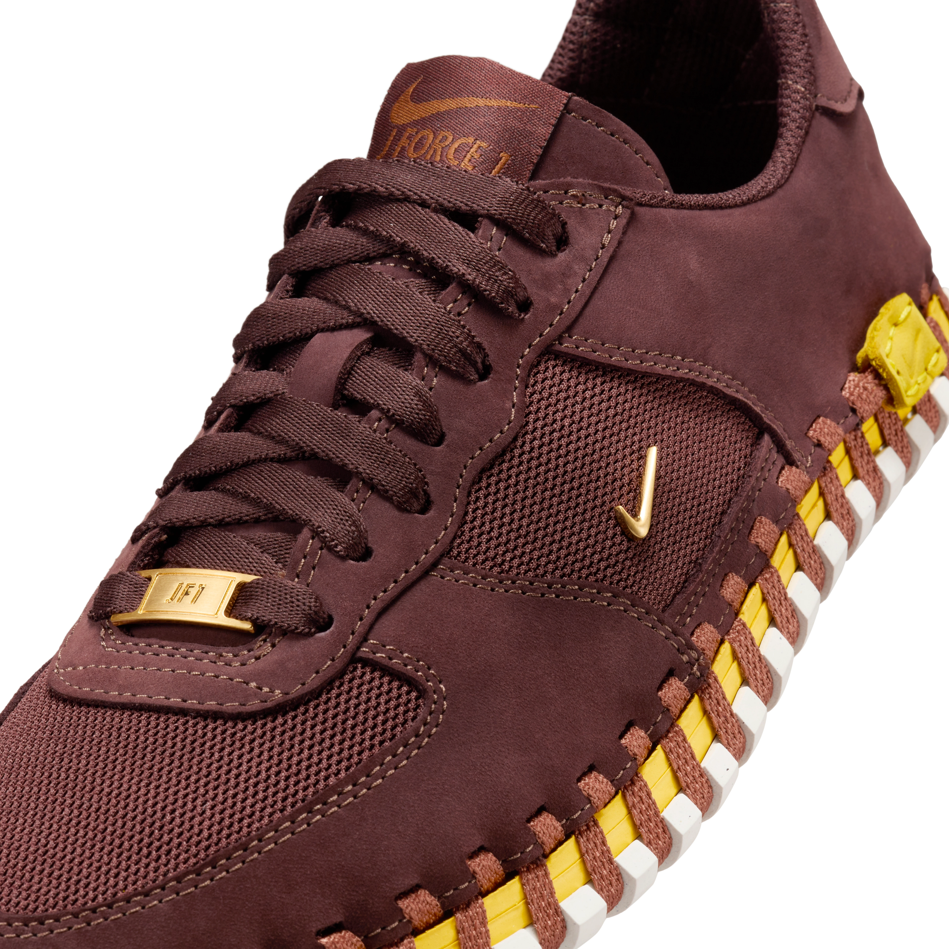 Front angled view of a Nike x Jacquemus J Force 1 Low LX SP with Earth brown upper, tour yellow midsole, and white sole. Includes, brown laces and AF1 lace tag in gold metal. The shoe floats on a black background.