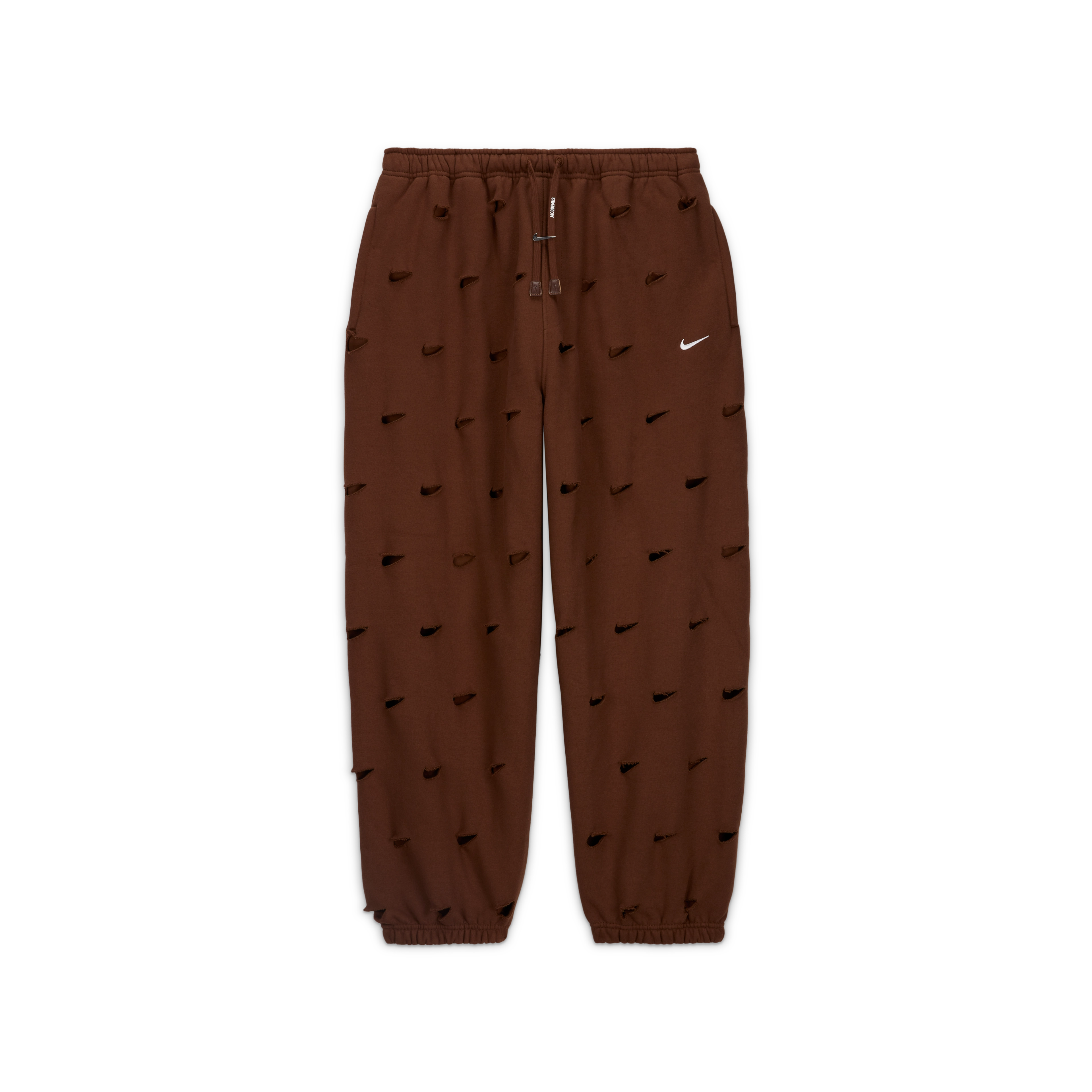 Overhead view of the Nike x Jacquemus Swoosh Pant in cacao wow brown. Laser cut Swooshes are placed over the entire pant and there is a silver Swoosh logo adorning the drawcord. The pant floats on a black background.