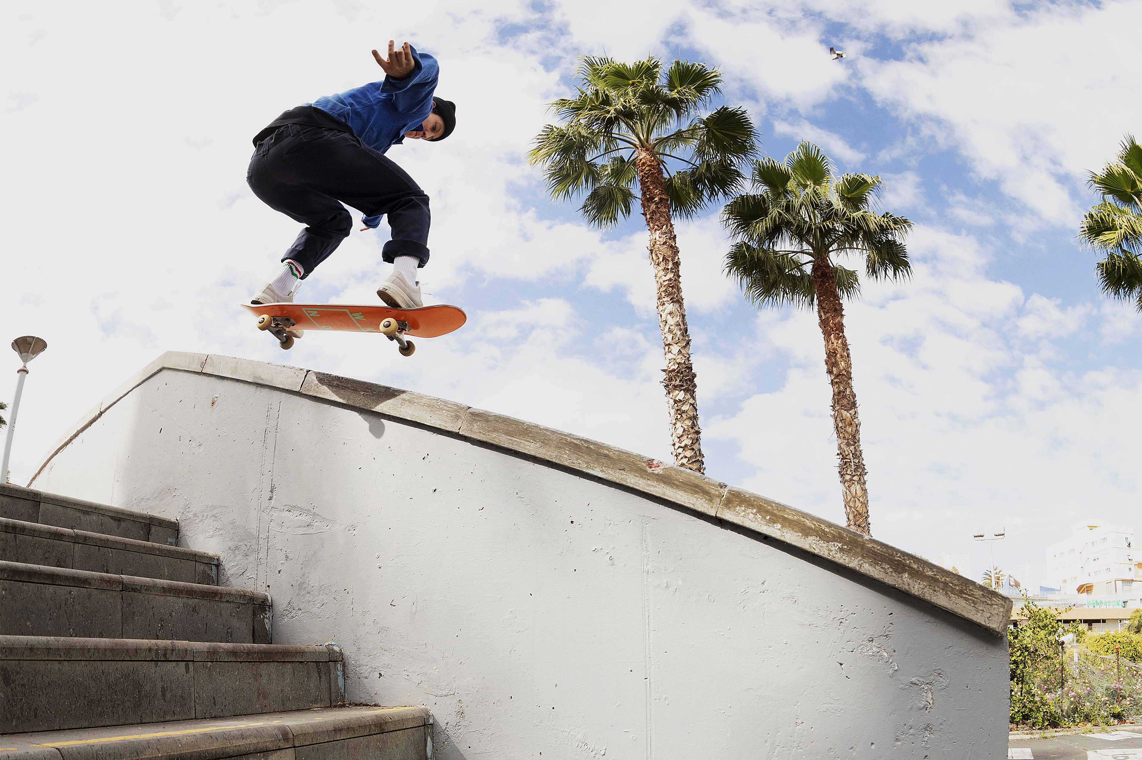 Alexis Sable mid air on her skateboard going over a set of stairs.