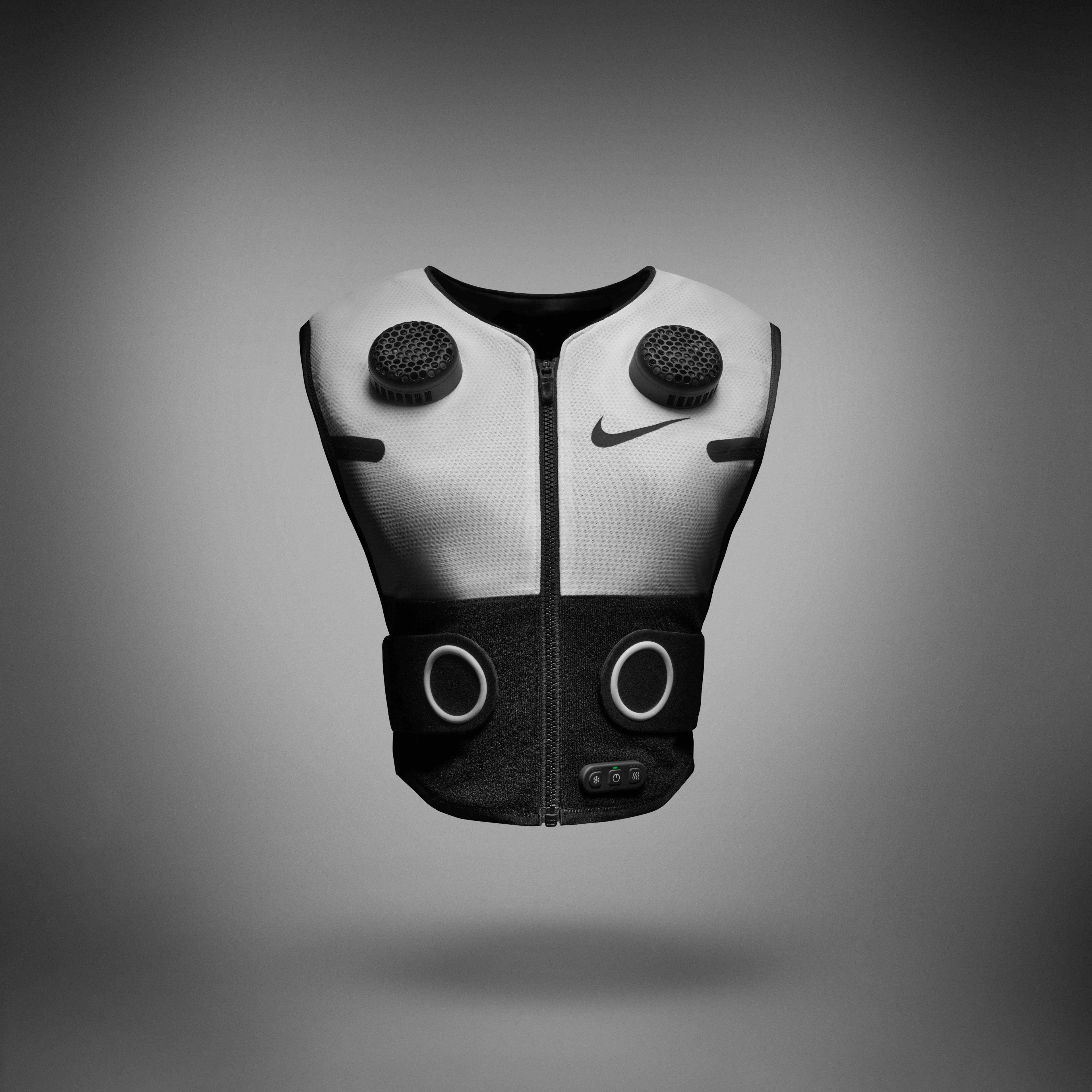 Front view of Nike x Hyperice Vest, shown in white with black thermal modules and compression tabs. Vest floats above a grey background, casting a shadow underneath.