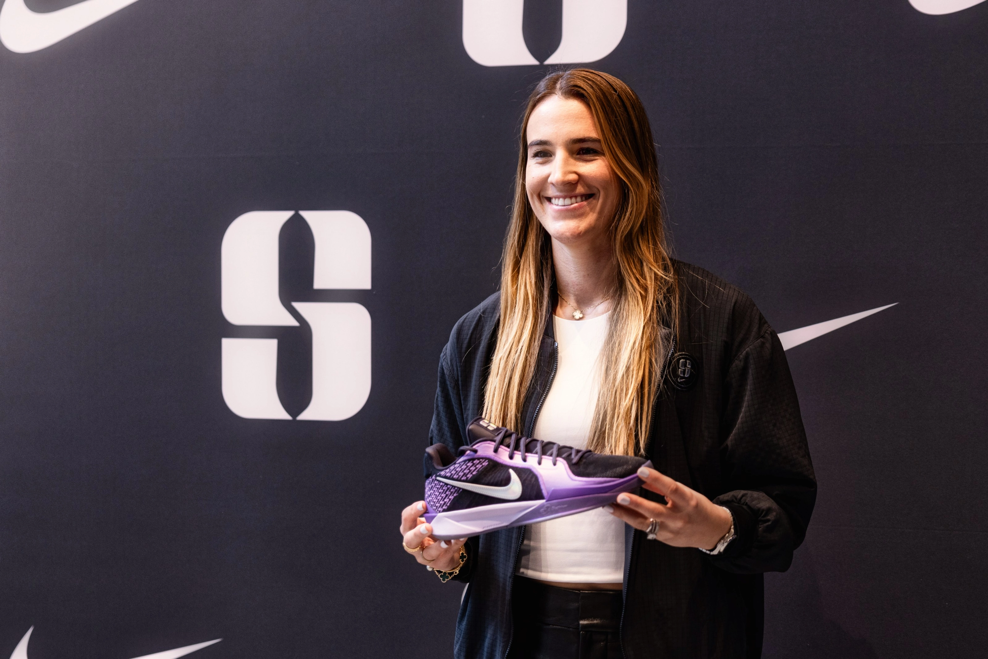 Sabrina Ionesco holding the Sabrina 2 shoe in black and purple at the collection launch in New York City