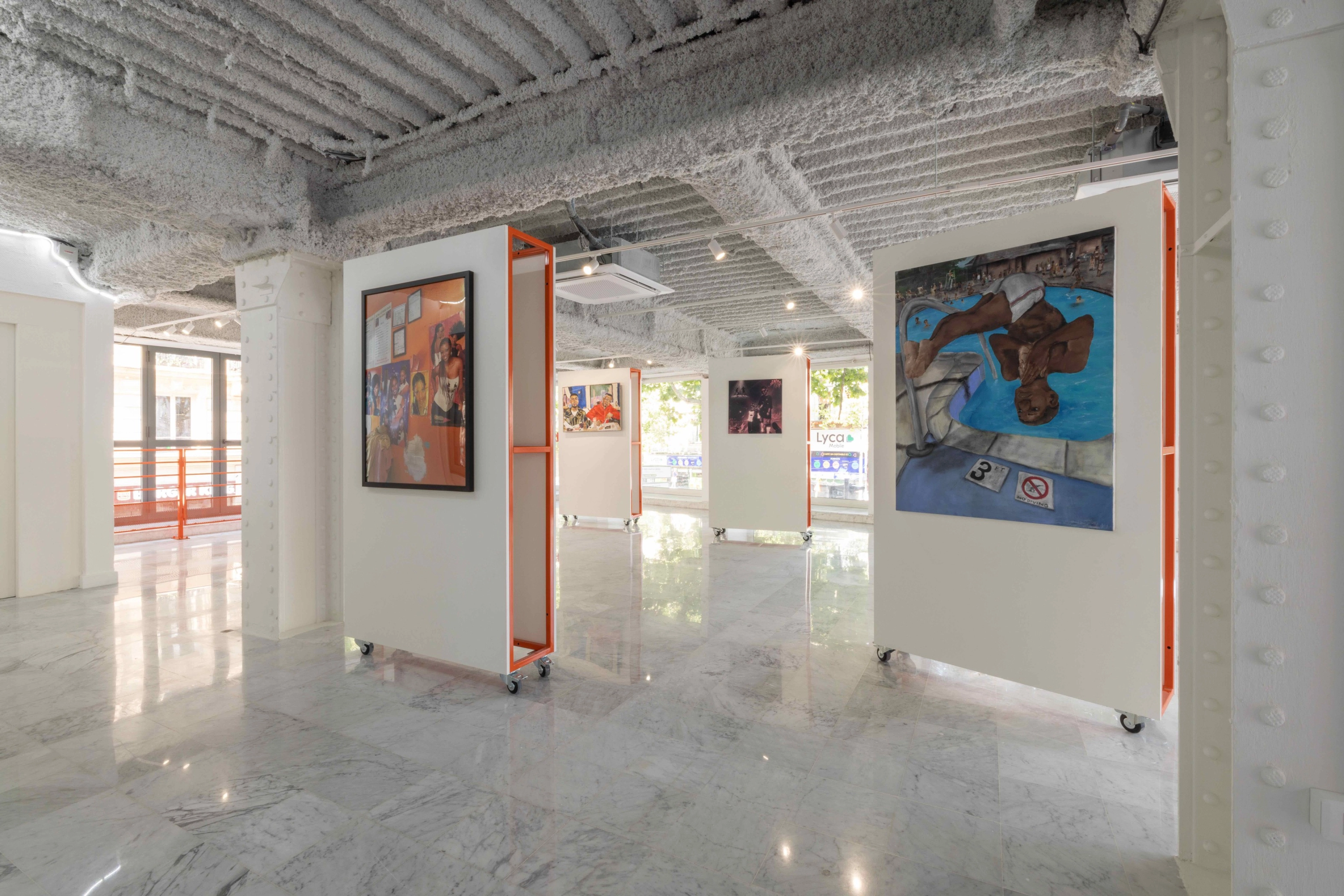 Photo of the District 23 gallery room. Artistic works are featured on rolling displays.