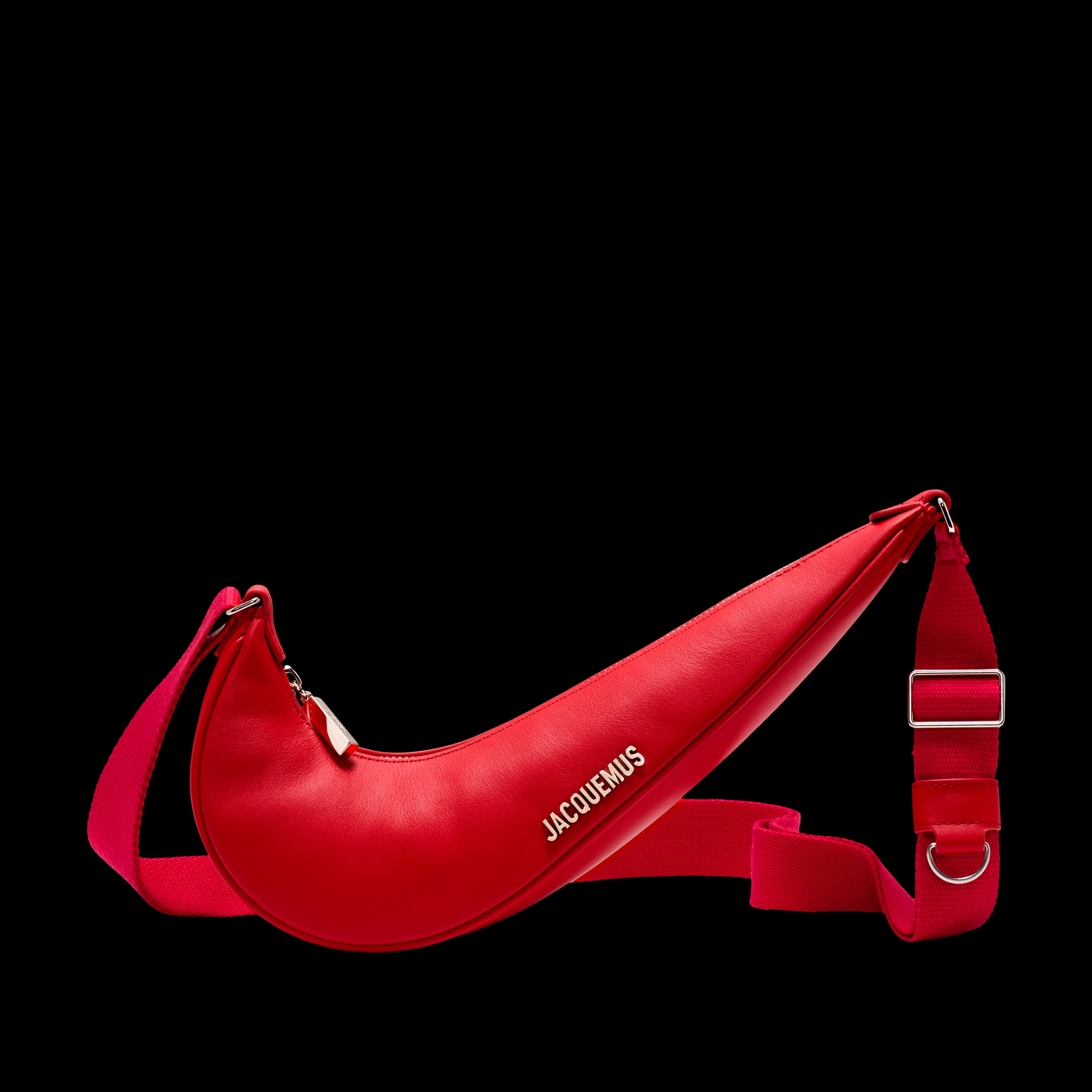 Front view of the Nike x Jacquemus Le Swoosh Crossbody Bag in university red, with bright silver bag hardware and Jacquemus brand mark. The bag itself is in the shape of a Nike Swoosh, and includes a red strap that is draped behind the body of the bag. The bag floats on a black background.
