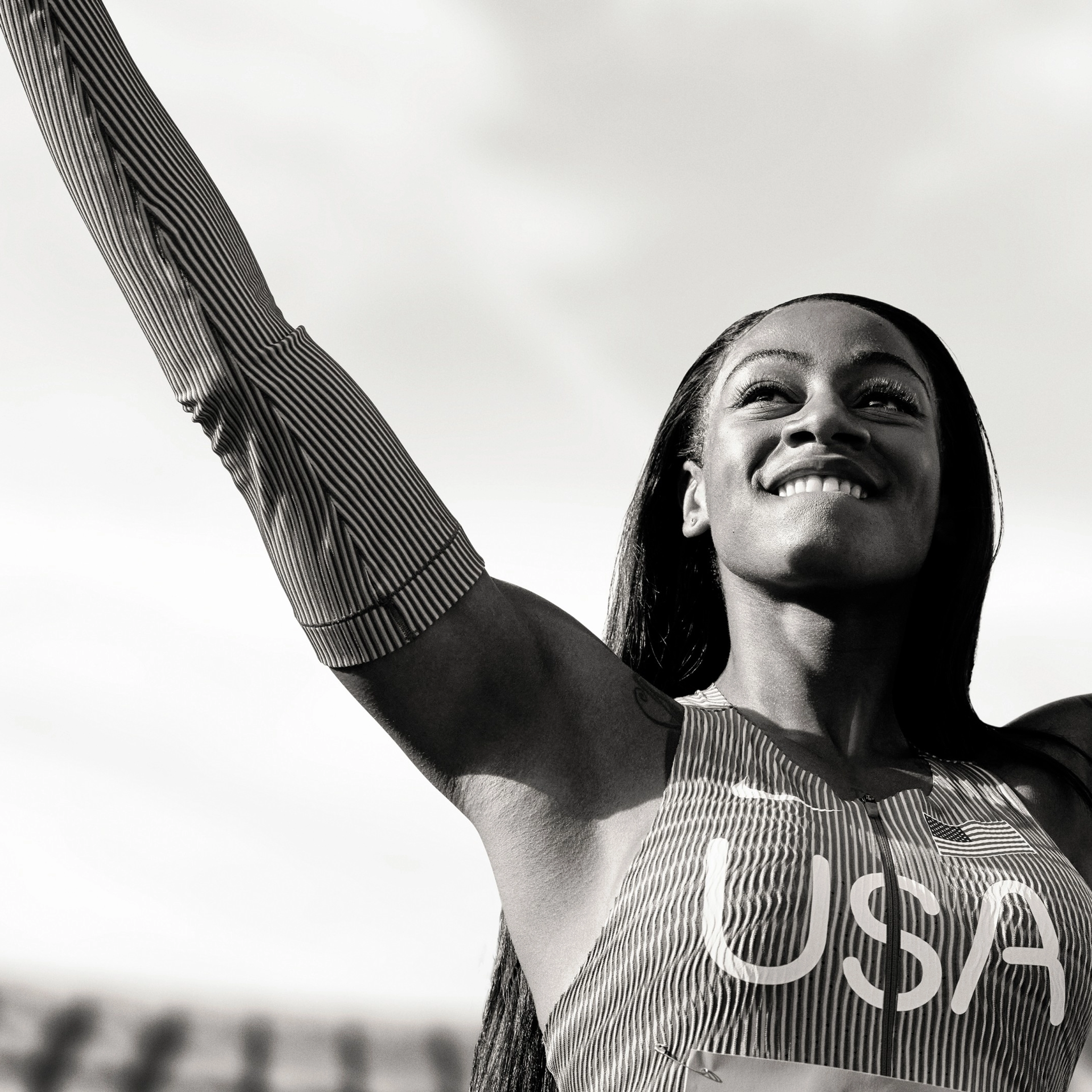Black and white photo of Sha'Carri Richardson striking a victory pose.