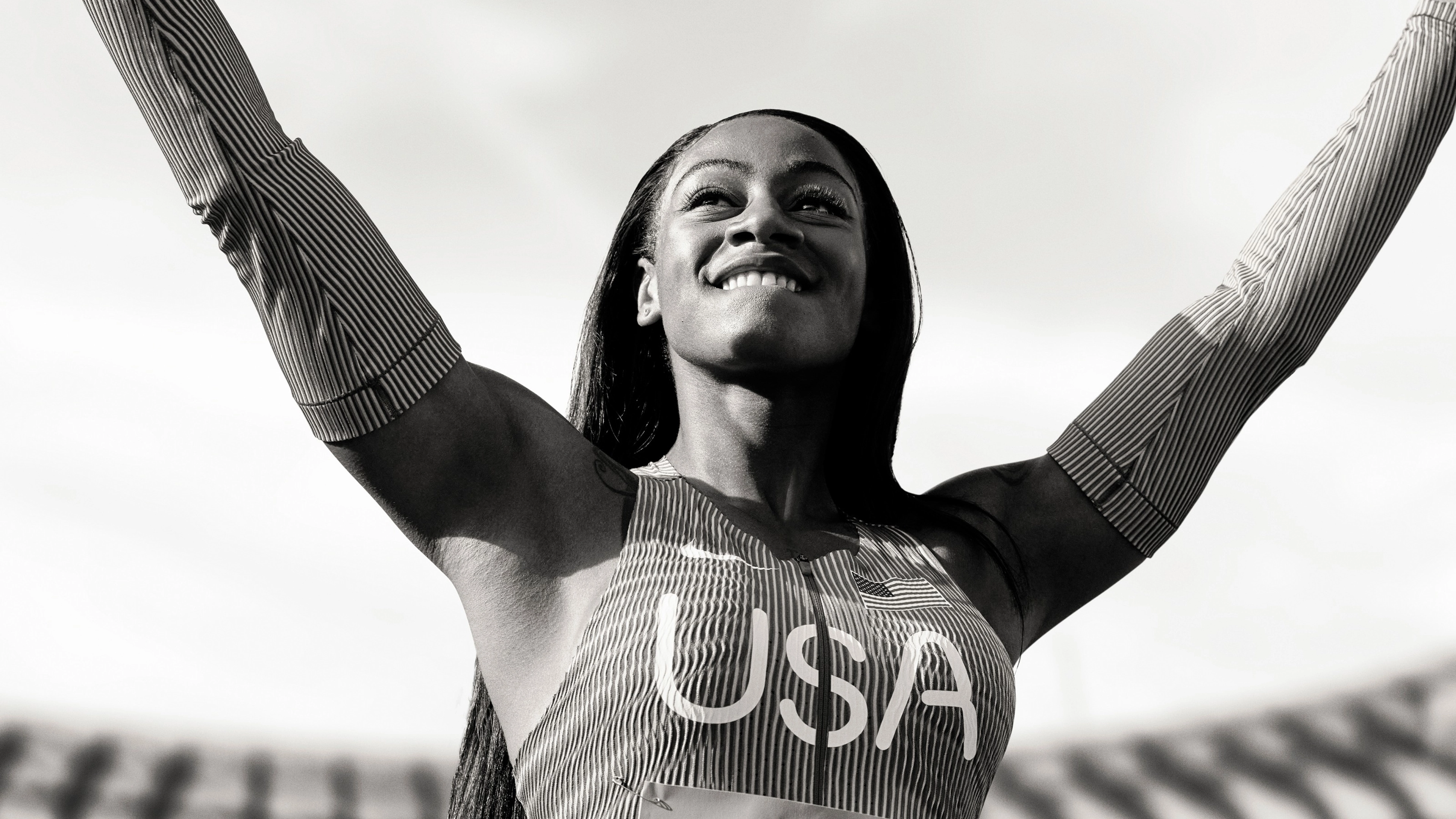 Black and white photo of Sha'Carri Richardson striking a victory pose.