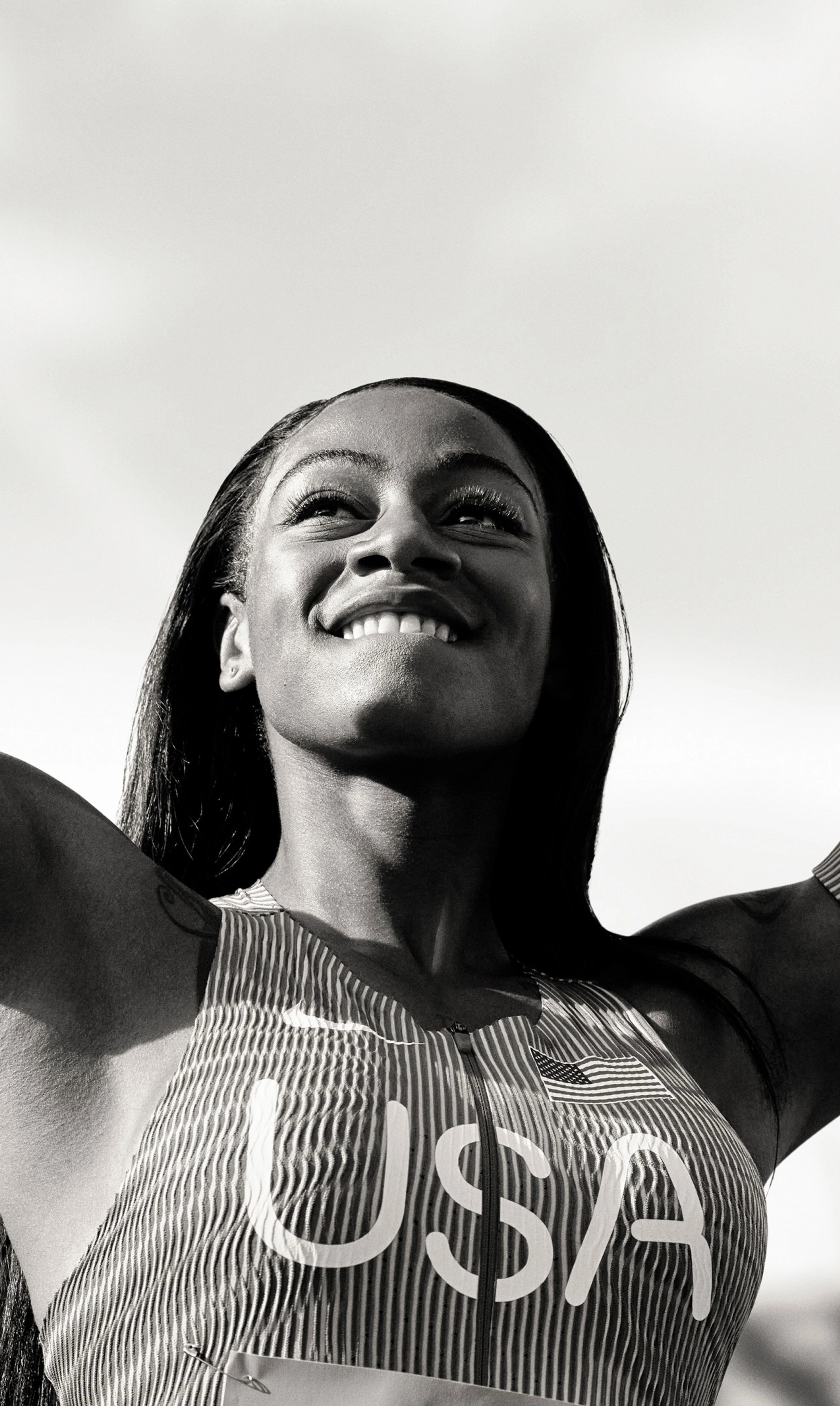 Black and white photo of Sha'Carri Richardson striking a victory pose.