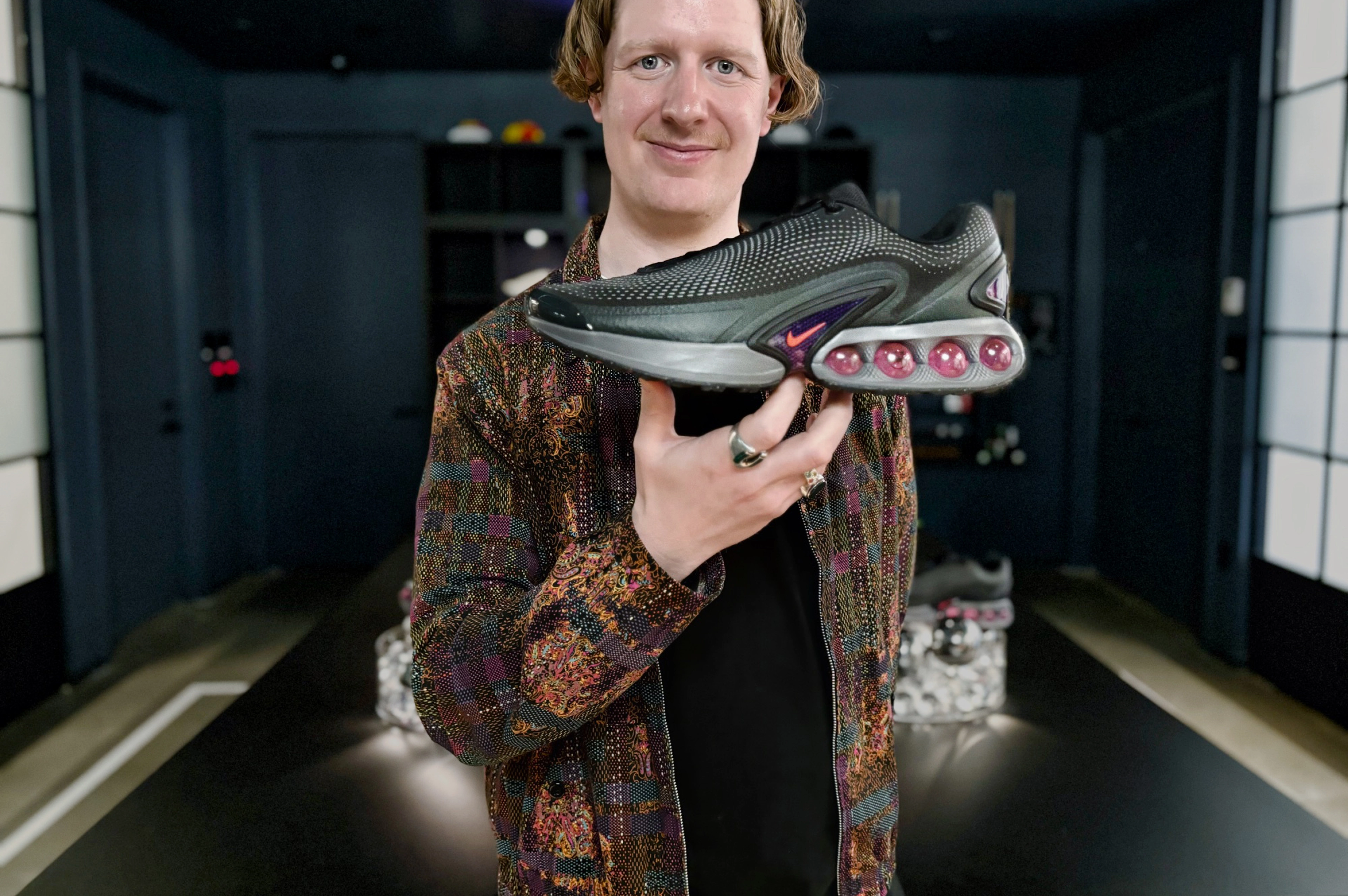 Nike Product Director Reggie Hunter holding up with his right hand the Nike Air Max Dn