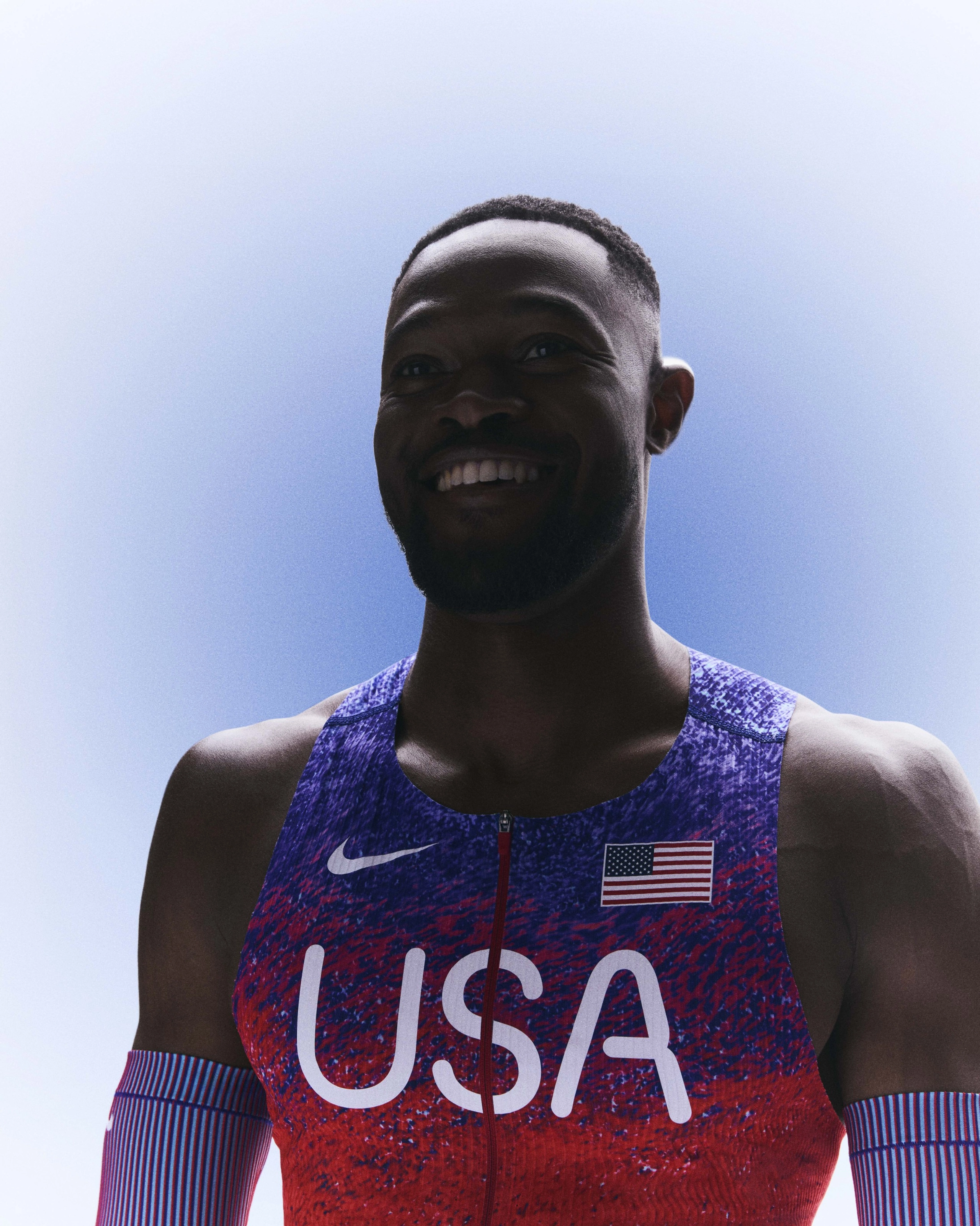 Rai Benjamin smiling while wearing his USA track and field kit uniform.