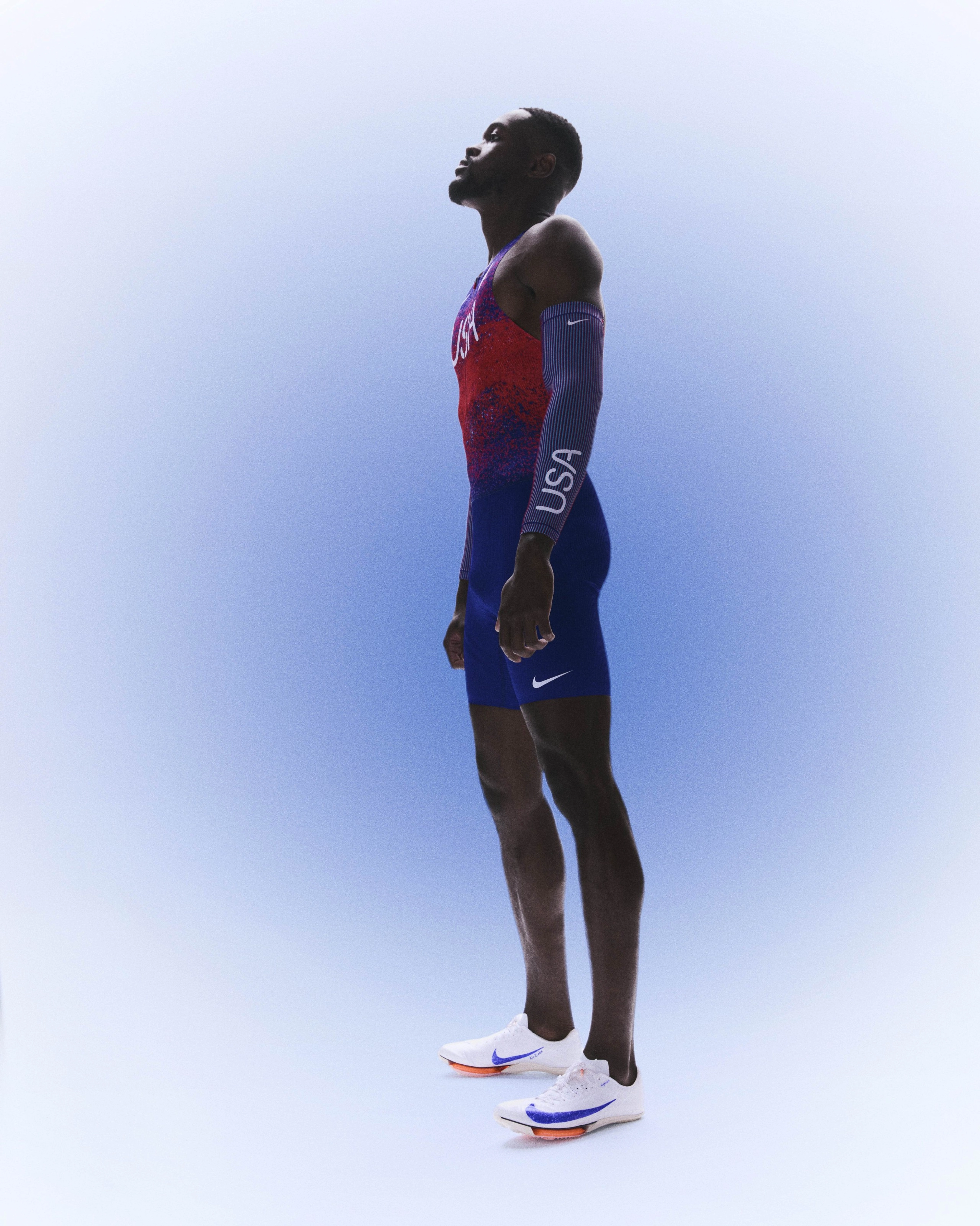 Kai Benjamin standing up with his head tilted up while wearing his USA track and field kit uniform.