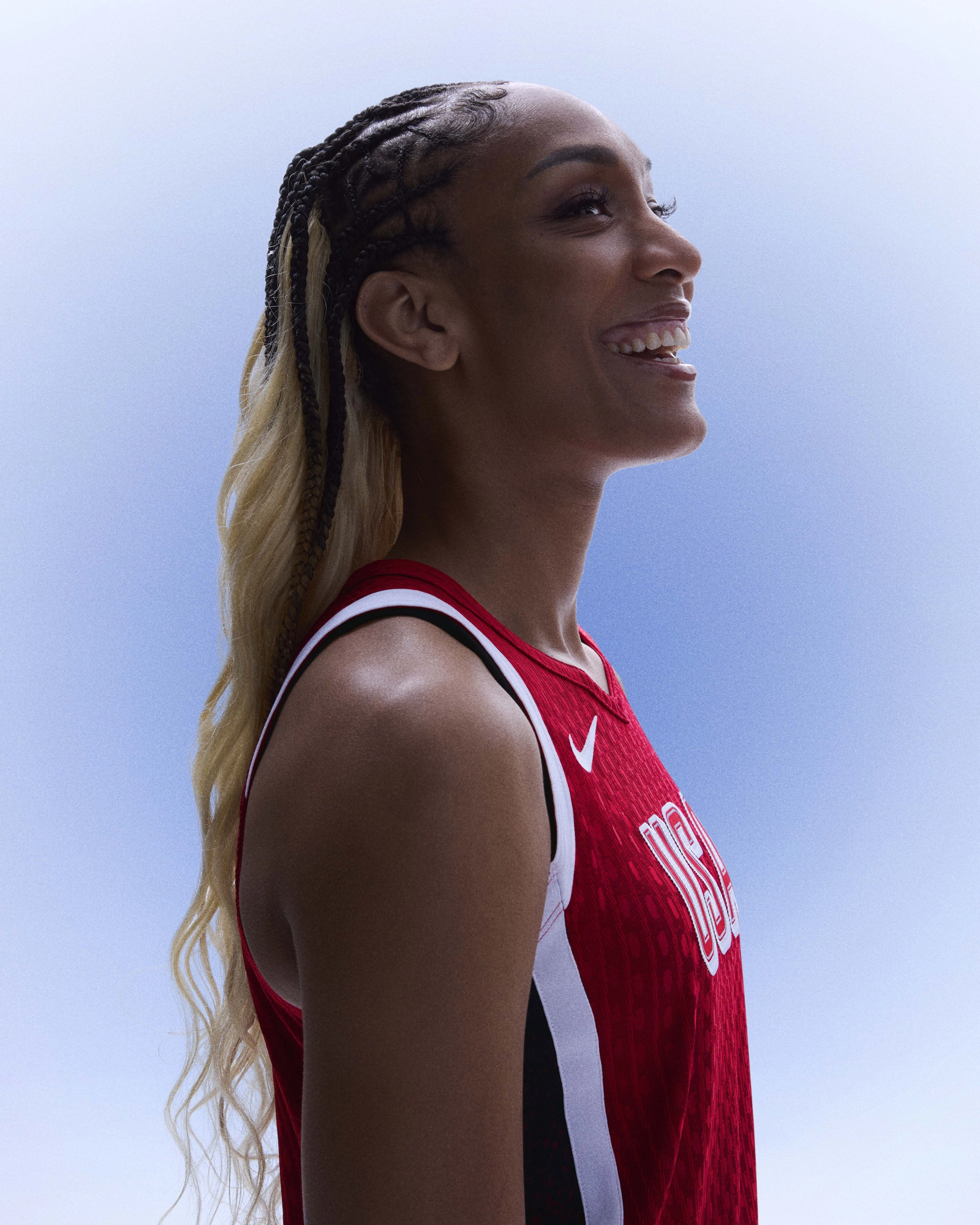 Right side view of A'ja Wilson smiling and wearing her Paris 2024 basketball kit uniform.