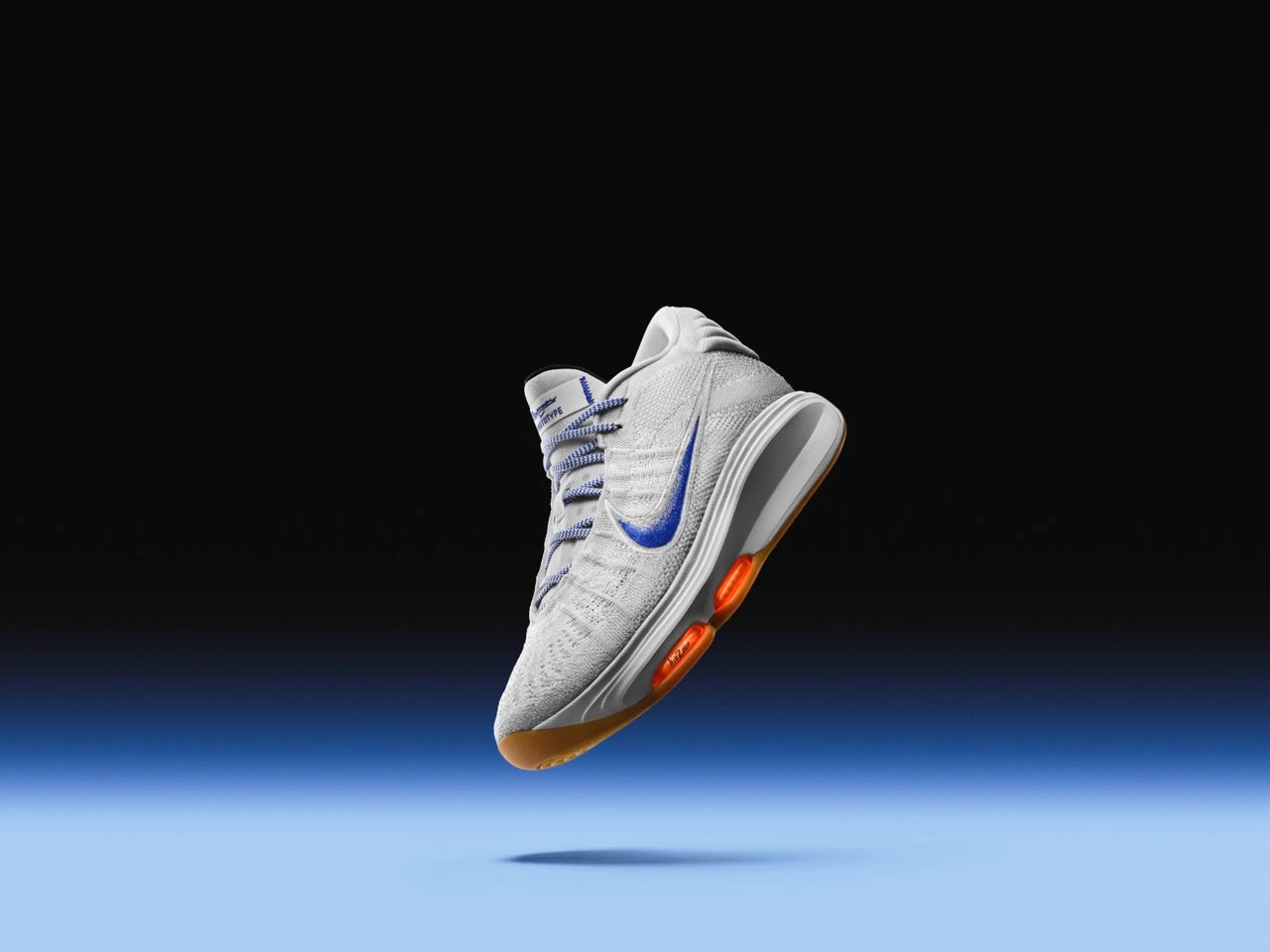 Right view of Nike GT Hustle 3 in the Blueprint colorway. White upper with a speckled blue Swoosh, orange Air Zoom units, and a gum sole tread. The shoe floats above a blue floor, against a black background.