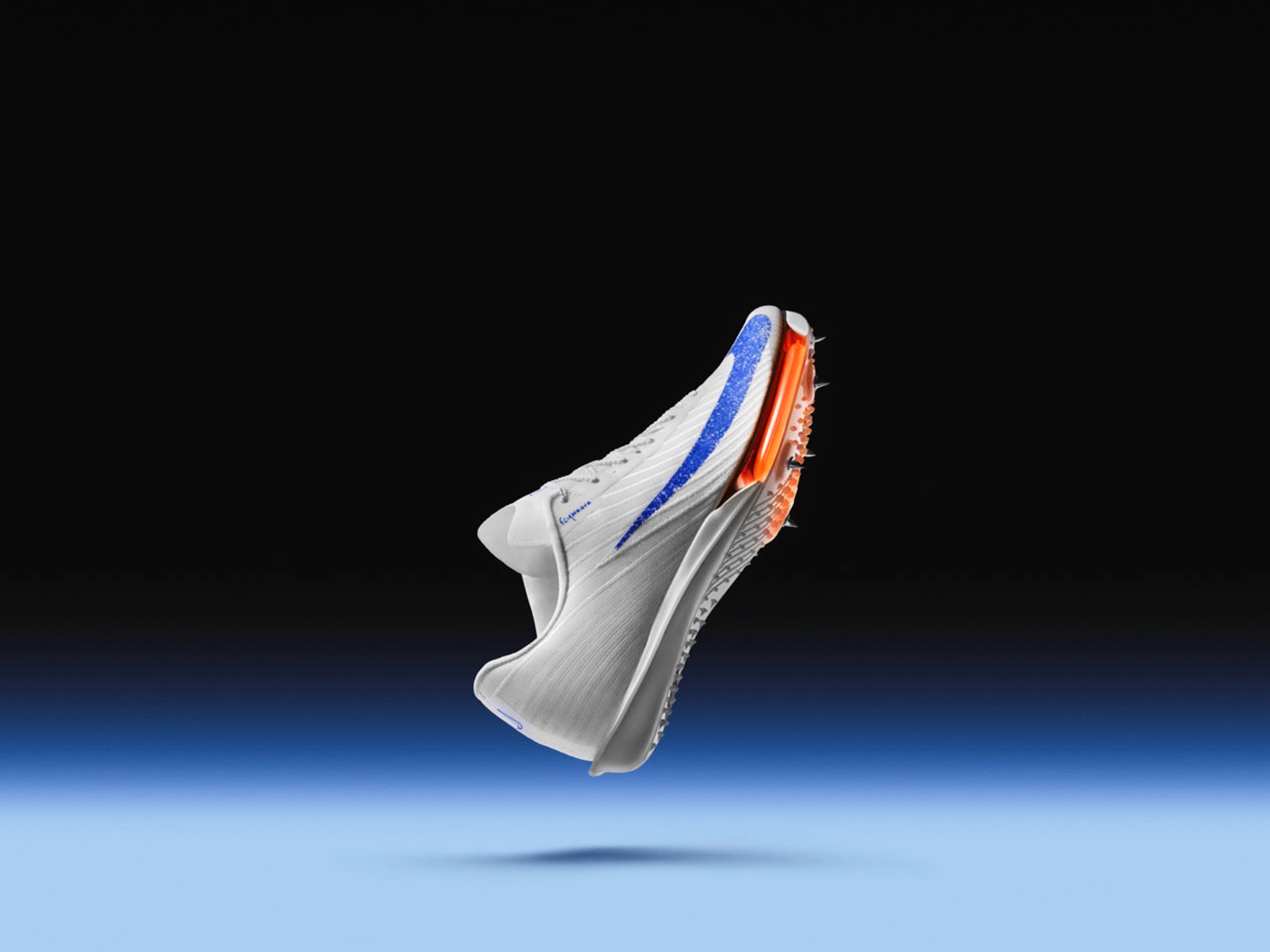 Right view of Nike Maxfly 2 spikes in Blueprint colorway. White upper with a speckled blue Swoosh, orange Air Zoom unit, and a white spike plate.  The shoe floats above a blue floor against a black background.