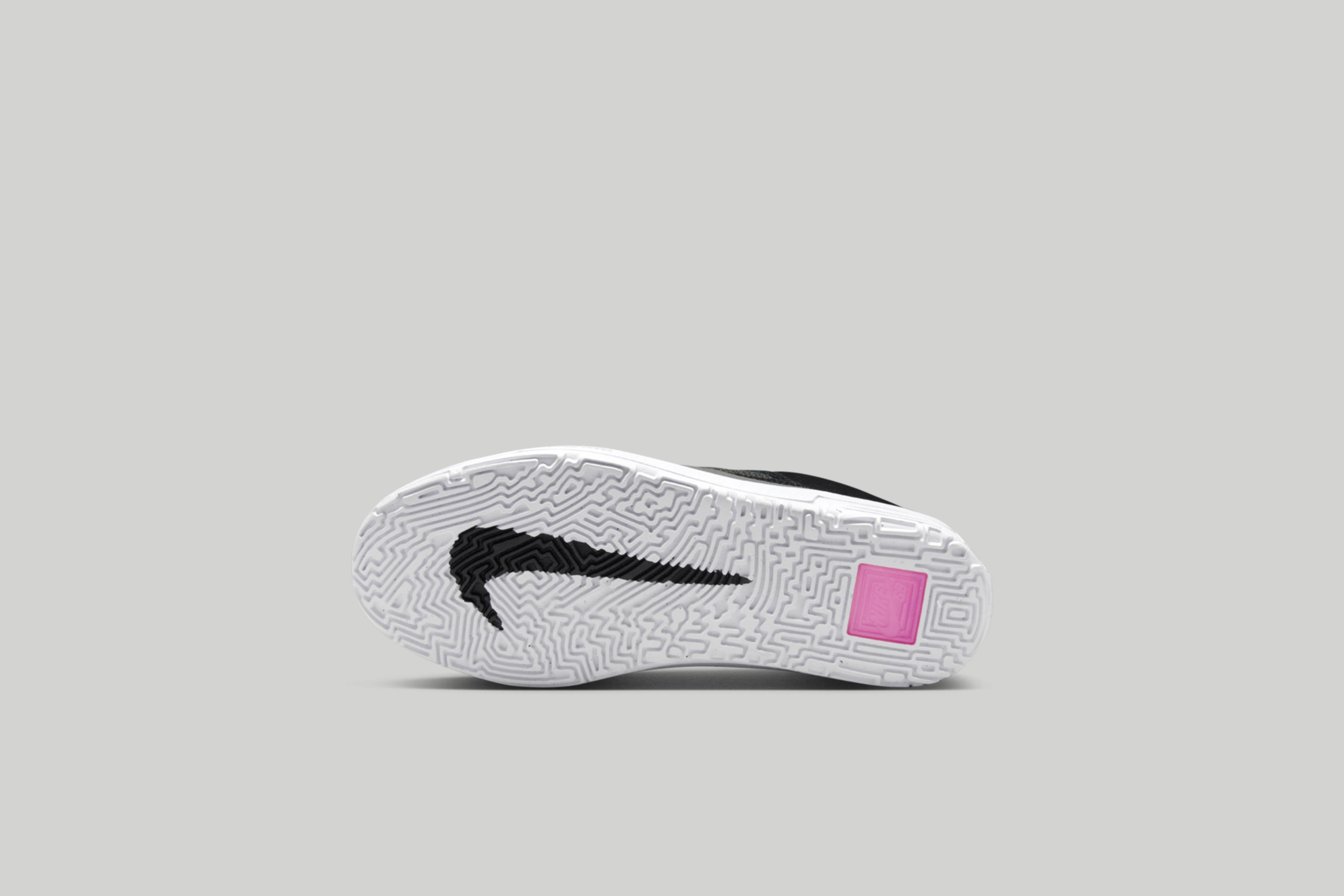 Underside view of the kids Nike SB Day One. White sole with a black nike swoosh logo.