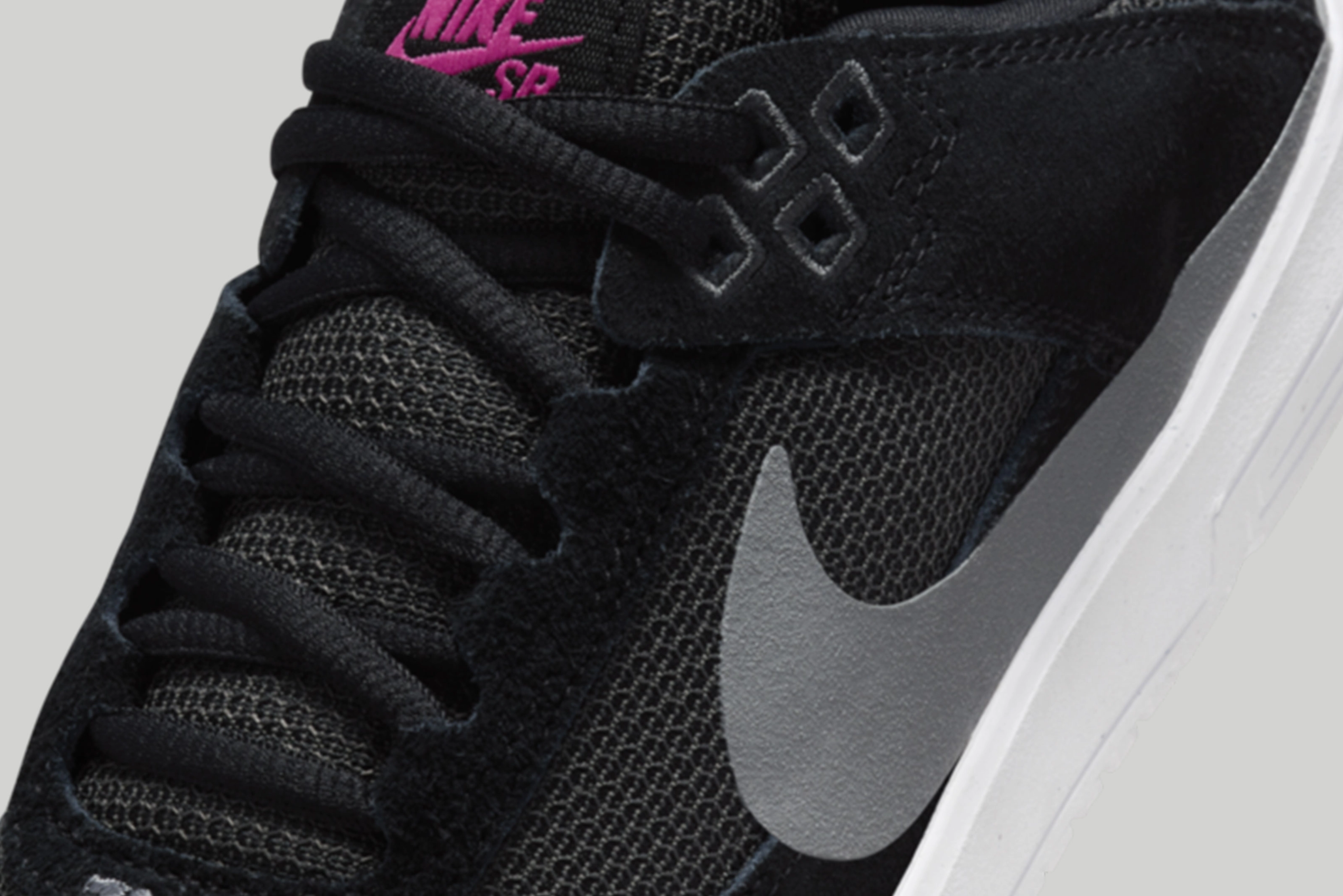 Detail view of the kids Nike SB Day One in black, featuring the upper combination of suede overlays and mesh paneling that helps make them breathable.