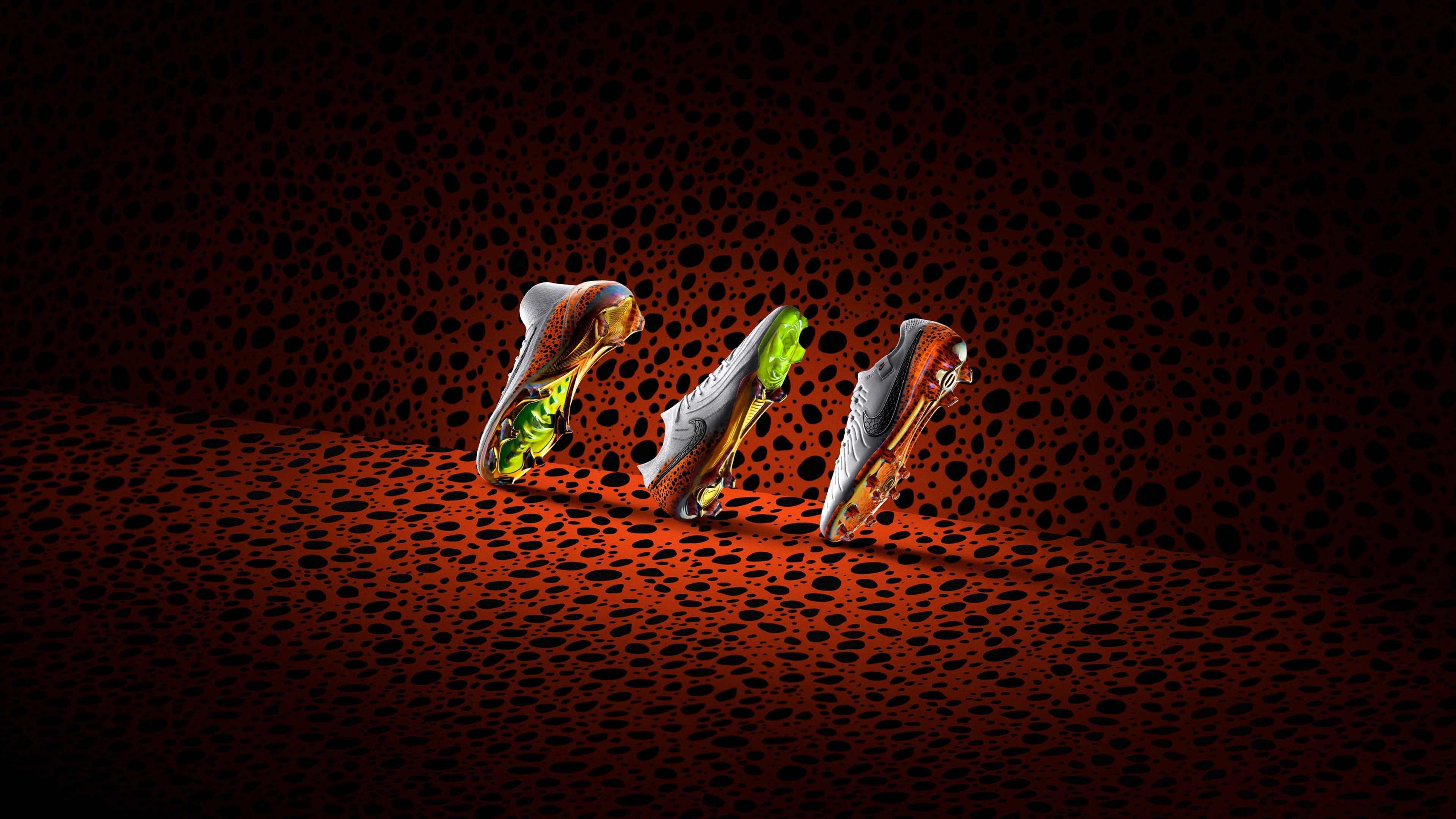 Side view of 3 Nike Electric Pack football boots, made up of Nike Air Zoom Mercurial Superfly, Nike Phantom GX 2, and Nike Tiempo Legend, all featuring the Electric pattern, orange with a speckled blue/black spots.