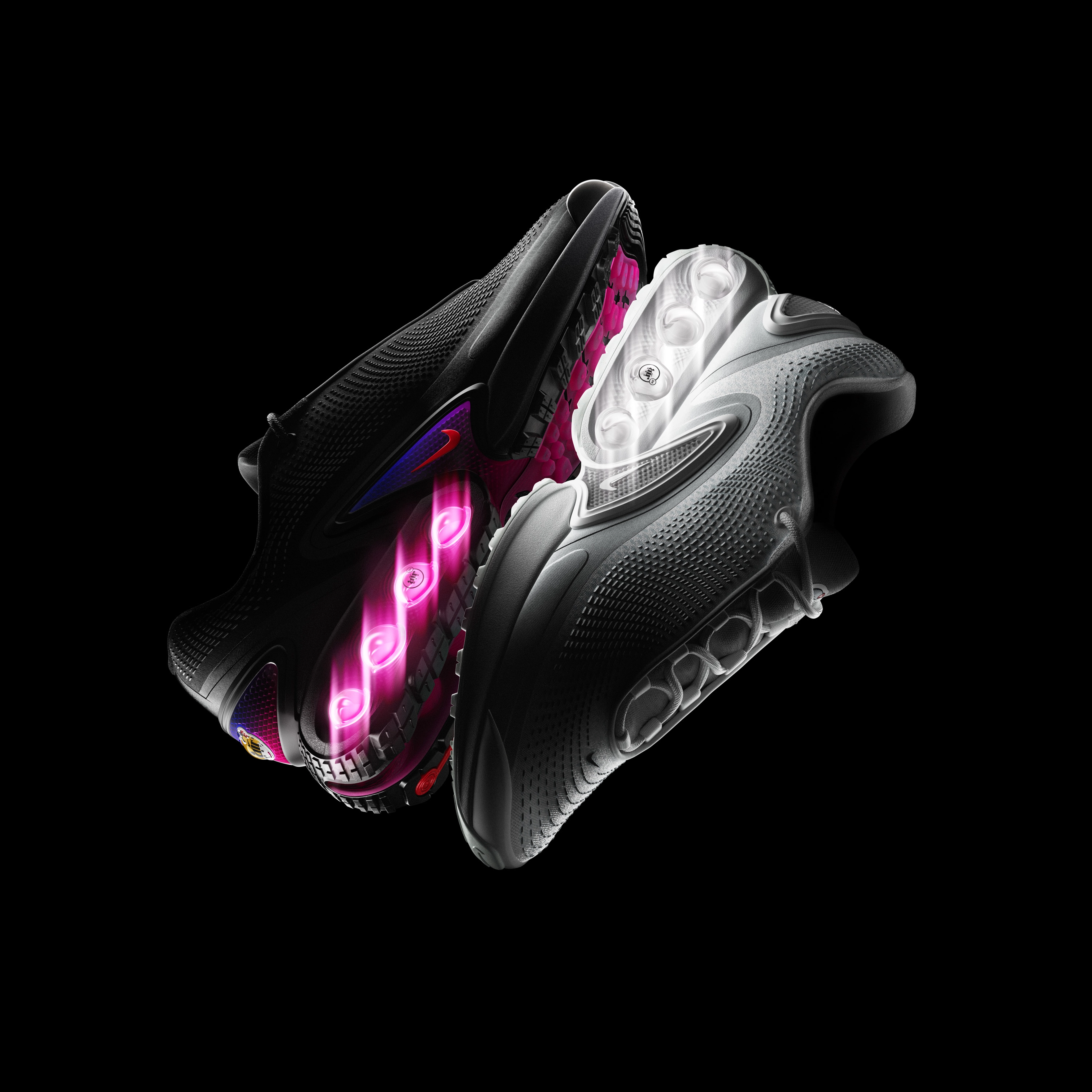 Reflective view of the Nike Air Max Dn in the white and all night color ways against a dark background