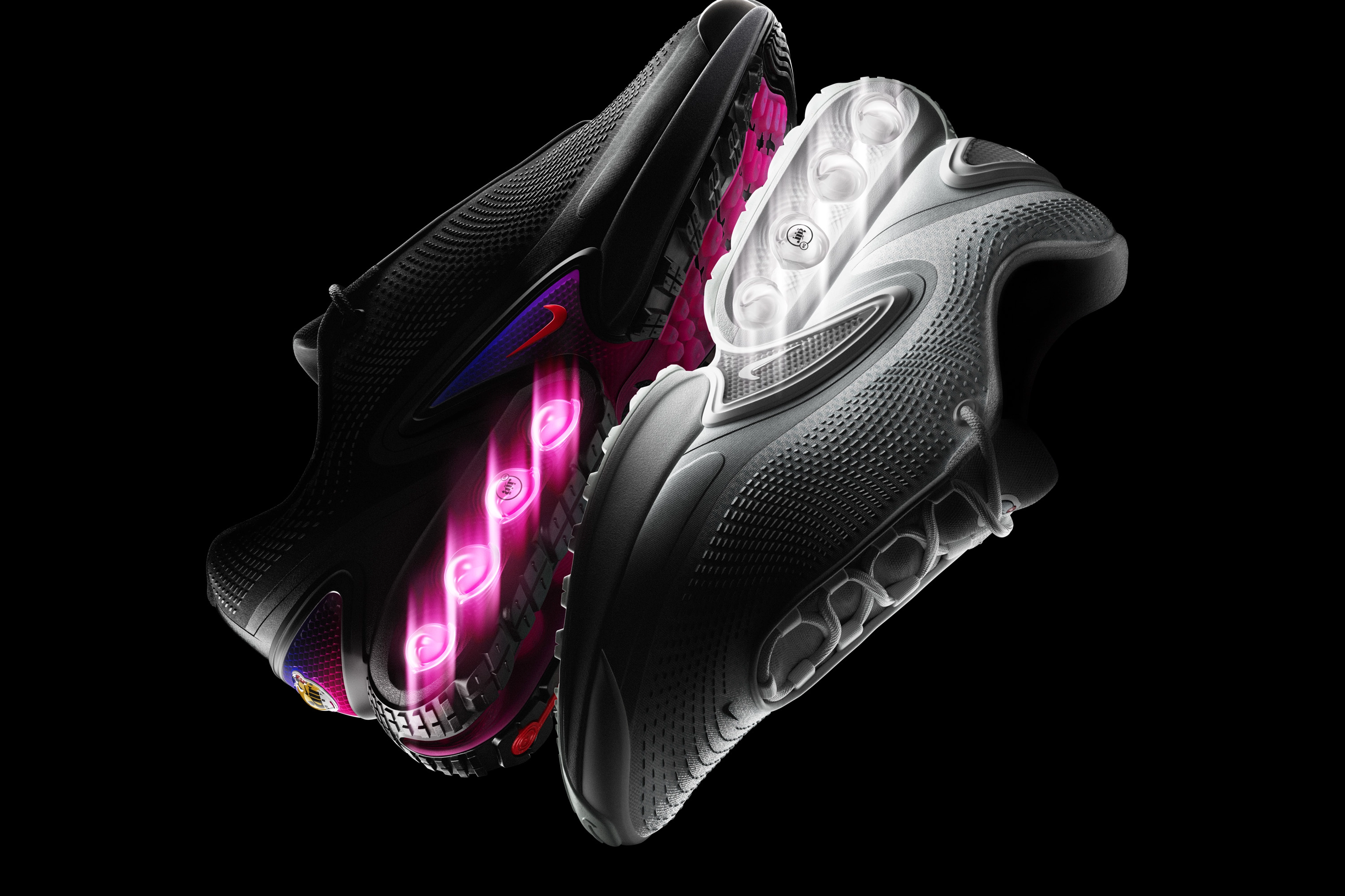 Reflective view of the Nike Air Max Dn in the white and all night color ways against a dark background