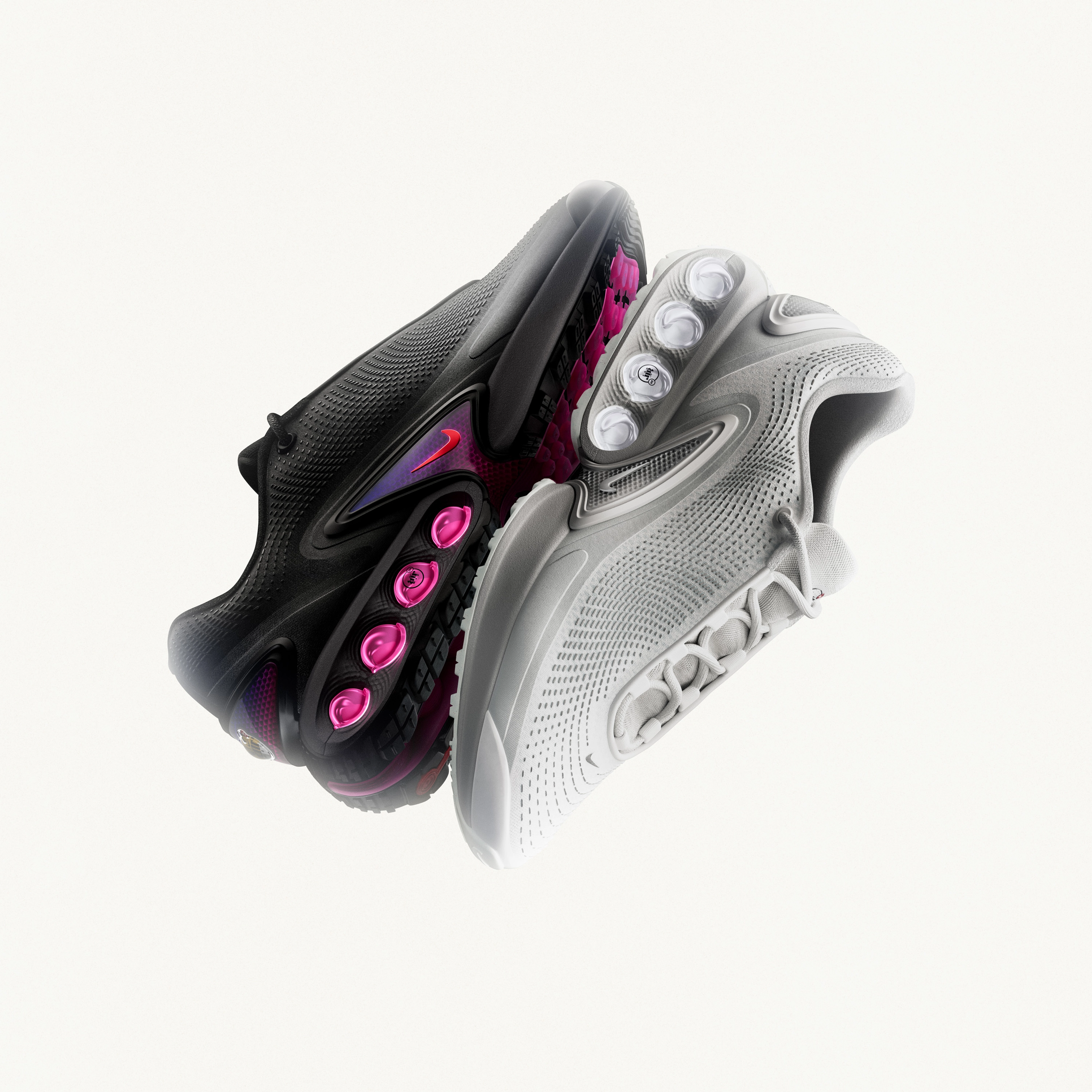 Reflective view of the Nike Air Max Dn in the white and all night color ways against a light background