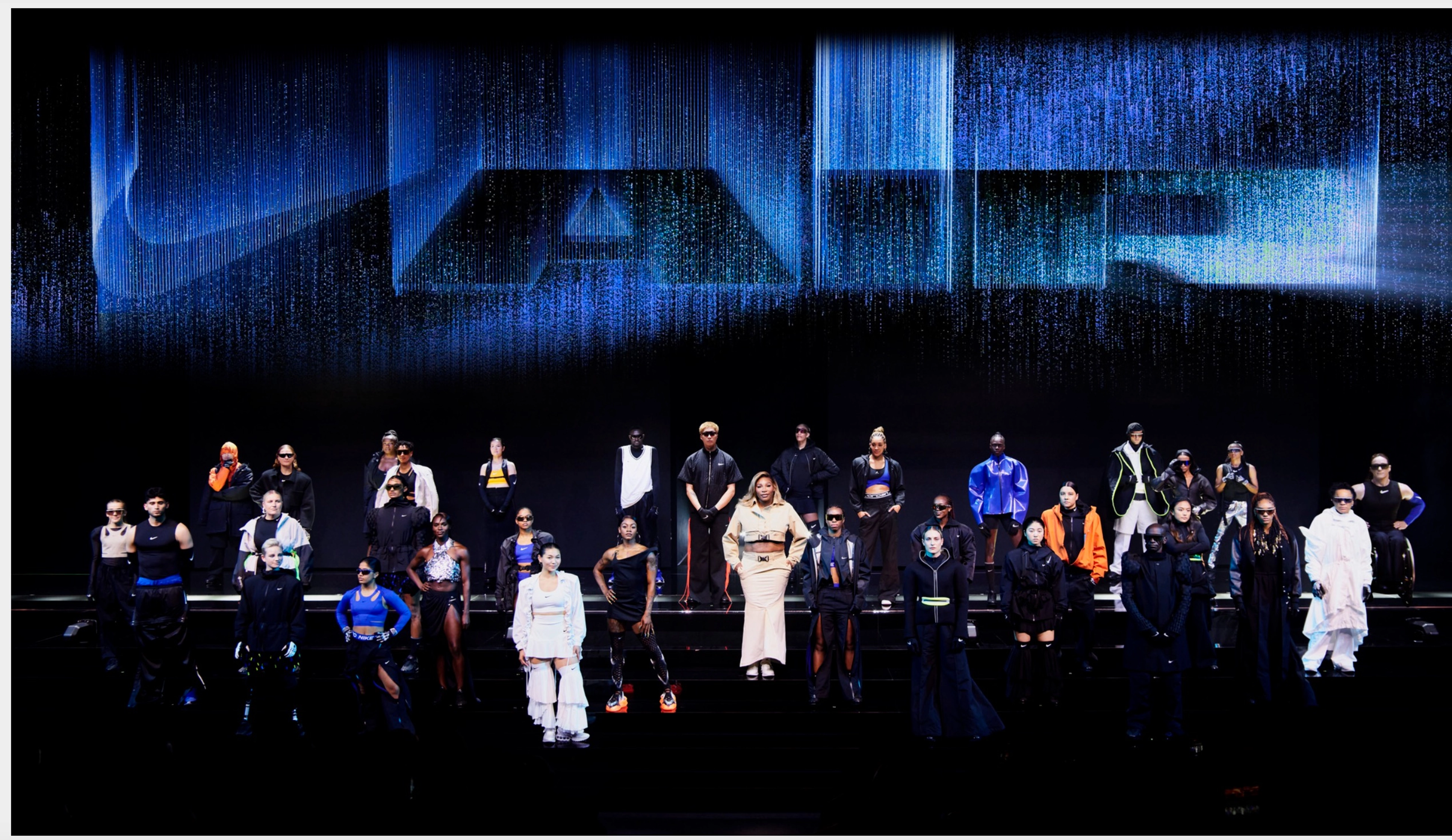 Athletes pose on a large stage wearing newly unveiled Nike products.